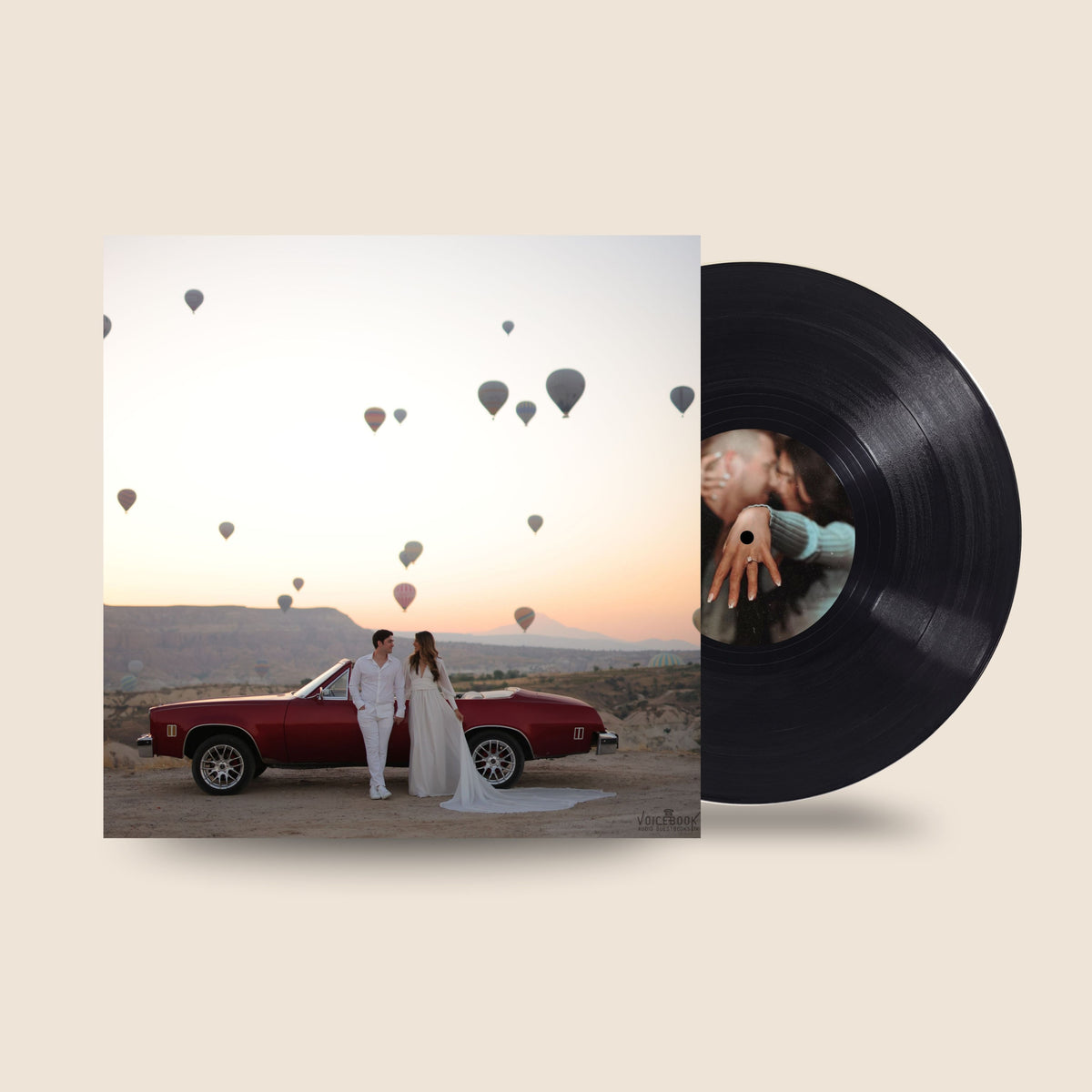 A vinyl record partially pulled from its sleeve, shown on a warm beige background. The sleeve features a square photograph of a bride and groom standing beside a red convertible with hot air balloons in the sky.