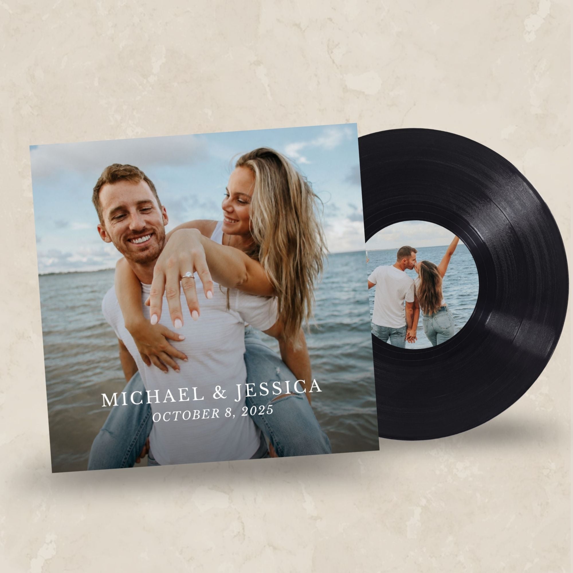 A custom vinyl record album cover and black vinyl record shown on a textured beige background. The square album cover features a photo of a couple embracing by the water with the text 'MICHAEL & JESSICA OCTOBER 8, 2025'.